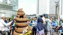 Sebuah maskot berbentuk kotoran ikut memeriahkan acara kampanye 'Toilet Sehat' saat Car Free Day (CFD) di Bundaran HI, Jakarta, Minggu (15/11/2015). (Liputan6.com/Yoppy Renato)