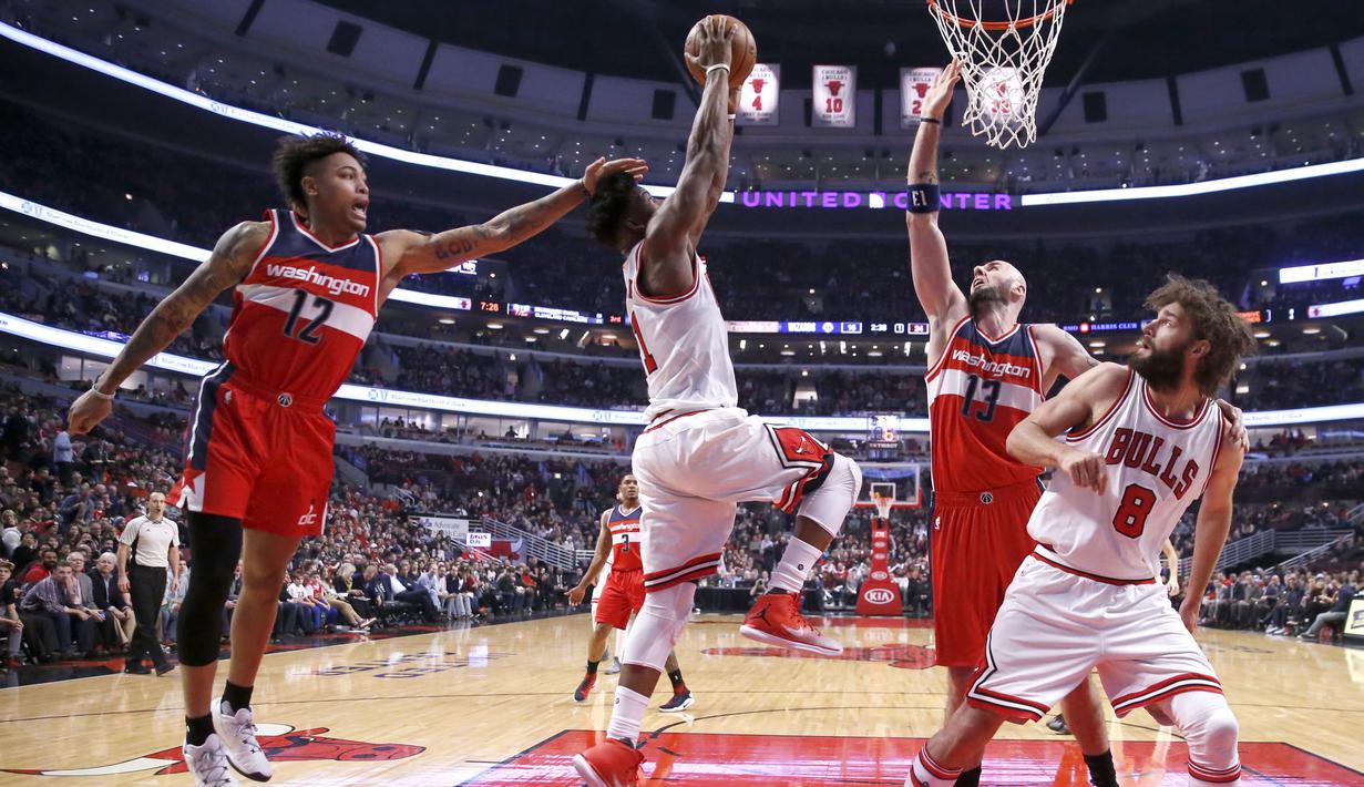 Pemain Washington Wizards, Kelly Oubre Jr. (kiri) melanggar pemain Chicago Bulls (dua kiri) Jimmy Butler  pada laga NBA basketball game di United Center, Chicago, (21/12/2016).  Wizards menang 107-97. (AP/Charles Rex Arbogast)