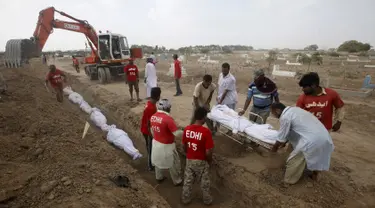 Relawan menguburkan jenazah korban tewas akibat gelombang panas saat pemakaman massal di Karachi, Pakistan, Jumat (26/6/2015). Lebih dari 1.150 orang tewas akibat gelombang panas. (REUTERS/Akhtar Soomro)