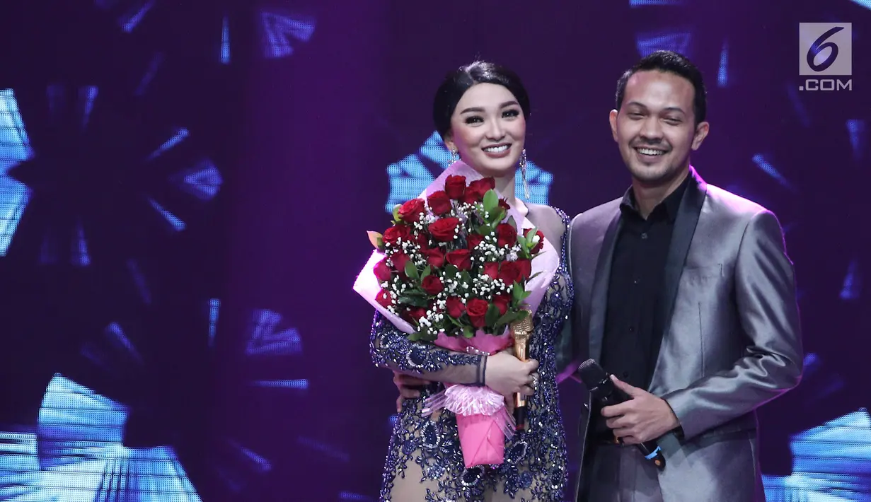 Zaskia Gotik bergandengan dengan kekasihnya Ryan usai lamaran diatas panggung Konser Lebaran Bidadari Dangdut di Studio 5 Indosiar, Jakarta, Senin (3/7). Zaskia pun menerimanya yang disambut dengan tepuk tangan penonton. (Liputan6.com/Herman Zakharia)