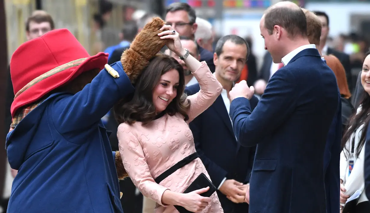 Kate Middleton asyik berdansa dengan seorang aktor yang mengenakan kostum Paddington di stasiun kereta Paddington, London, Senin (16/10). Kate memberi kejutan dalam acara yang melibatkan anak-anak dari yayasan amal yang didukungnya (Chris J Ratcliffe/AFP)
