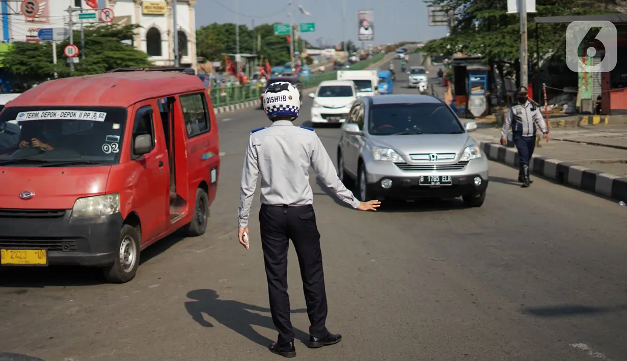 Petugas Dishub mengatur lalu lintas saat melakukan sosialisasi penggunaan masker kepada pengendara sepeda motor di kawasan Depok, Jawa Barat, Senin (20/7/2020). Setelah sosialisasi, Pemkot Depok akan menerapkan sanksi denda kepada warga yang melanggar. (Liputan6.com/Immanuel Antonius)
