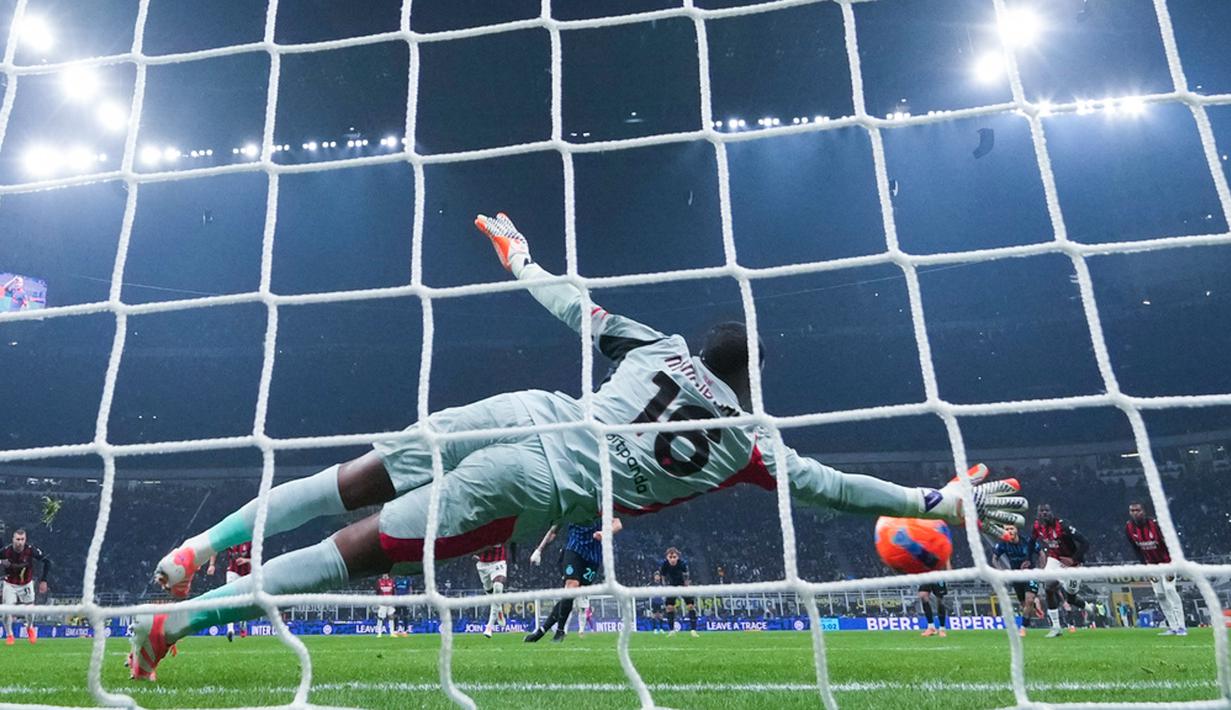 Kiper AC Milan, Mike Maignan, berhasil menggagalkan tendangan penalti pemain Inter Milan, Hakan Calhanoglu, pada laga Italia di Stadion Giuseppe Meazza, Senin (2411/2025). (AP Photo/Antonio Calanni)