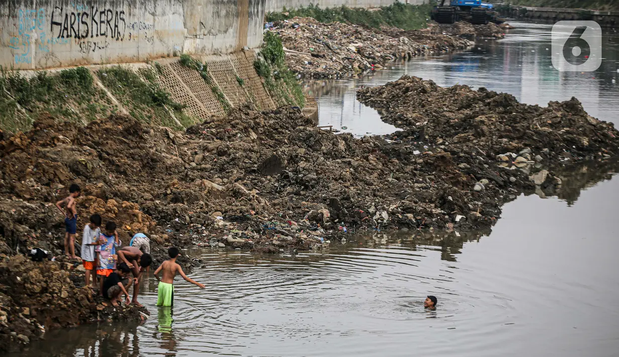 Anak-anak bermain di Sungai Ciliwung yang surut di kawasan Bukit Duri, Jakarta, Sabtu (8/8/2020). Penyusutan debit air Sungai Ciliwung tersebut karena memasuki masa kemarau 2020 yang menurut BMKG akan mencapai puncaknya pada Agustus. (Liputan6.com/Faizal Fanani)