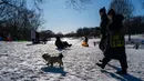 Orang-orang berjalan melewati salju di Prospect Park Brooklyn pada sore hari di musim dingin tanggal 21 Januari 2024 di New York City. (SPENCER PLATT/GETTY IMAGES NORTH AMERICA/Getty Images via AFP)