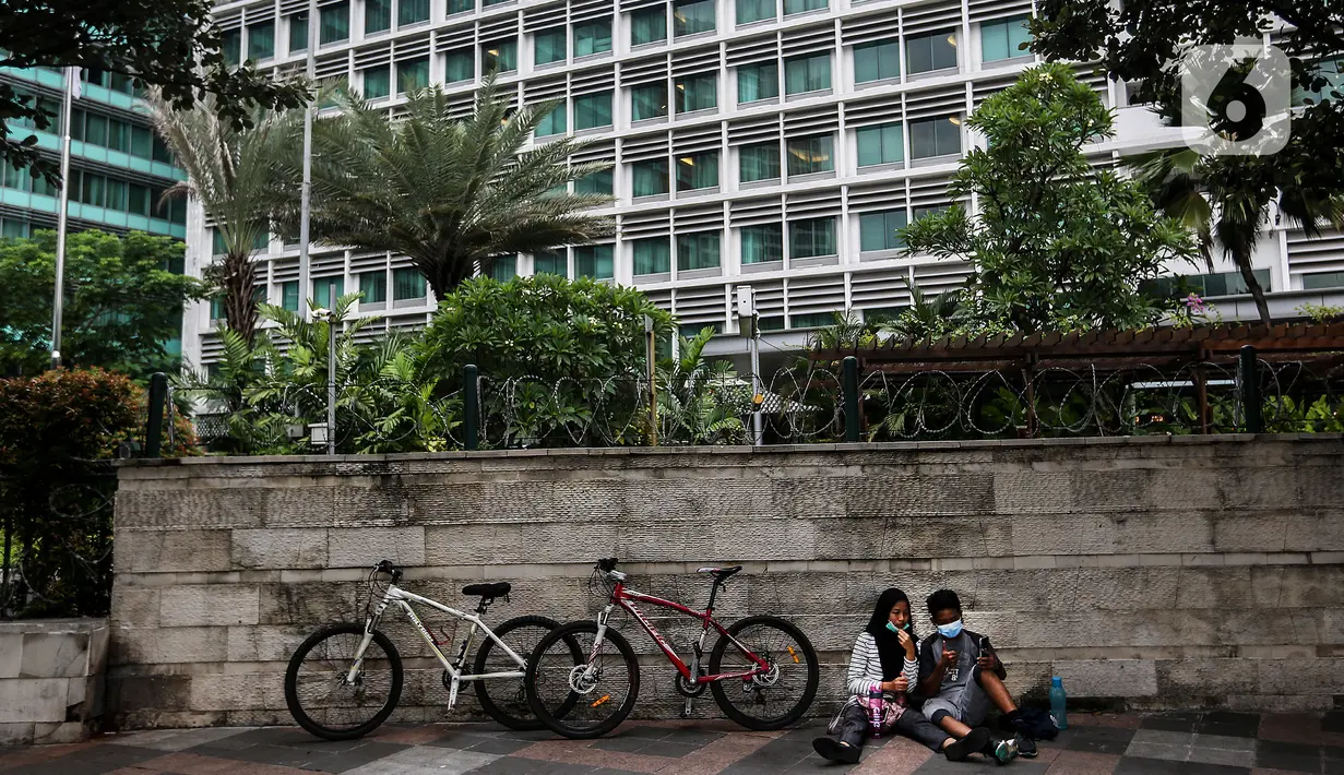 Aktivitas warga pada masa PSBB transisi di kawasan Bundaran HI, Jakarta, Minggu (6/12/2020). Ikatan Dokter Indonesia (IDI) Jakarta meminta pembatasan sosial berskala besar (PSBB) kembali diperketat untuk mengantisipasi tren kasus Covid-19 yang terus melonjak di Ibu Kota (Liputan6.com/Johan Tallo)