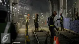 Para pekerja membersihkan jalur rel di terowongan Mass Rapid Transit (MRT) di Dukuh Atas, Jakarta, Jumat (30/9). Jumlah stasiun yang dilalui di rute tersebut sebanyak 13 stasiun. (Liputan6.com/Faizal Fanani)