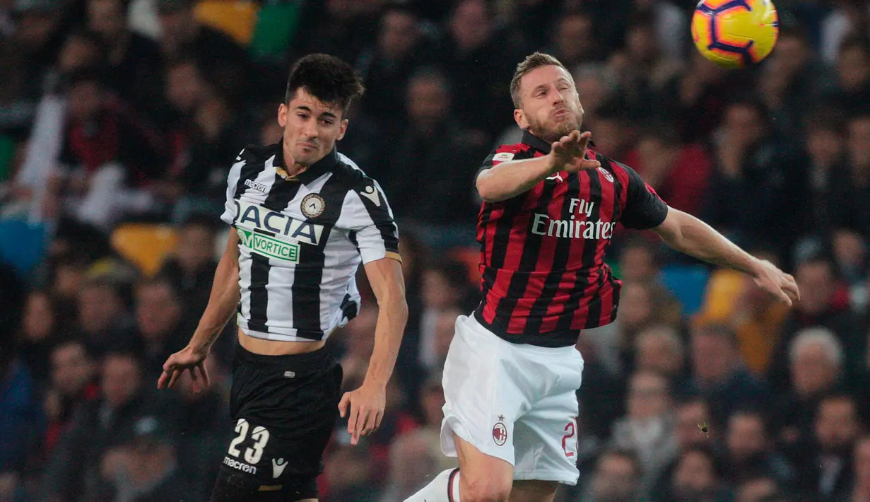 Pemain Udinese, Ignacio Pussetto berebut bola udara dengan bek AC Milan, Ignazio Abate saat bertanding di Liga Italia di stadion Friuli Dacia Arena, Italia (4/11). Milan menang tipis atas Udinese 1-0. (AP Photo/Sefano Lancia)