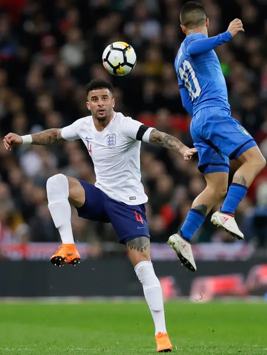 Pemain timnas Inggris, Kyle Walker berebut bola dengan pemain timnas Italia, Lorenzo Insigne dalam laga persahabatan di Stadion Wembley, London, Rabu (28/3).  Inggris gagal meraih kemenangan setelah ditahan Italia 1-1. (AP Photo/Alastair Grant)
