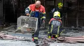 Seorang petugas pemadam kebakaran membawa ayam yang terluka di dalam kandang setelah kebakaran di pasar hewan peliharaan di sebelah pasar Chatuchak di Bangkok, Thailand pada 11 Juni 2024. (Chanakarn Laosarakham/AFP)