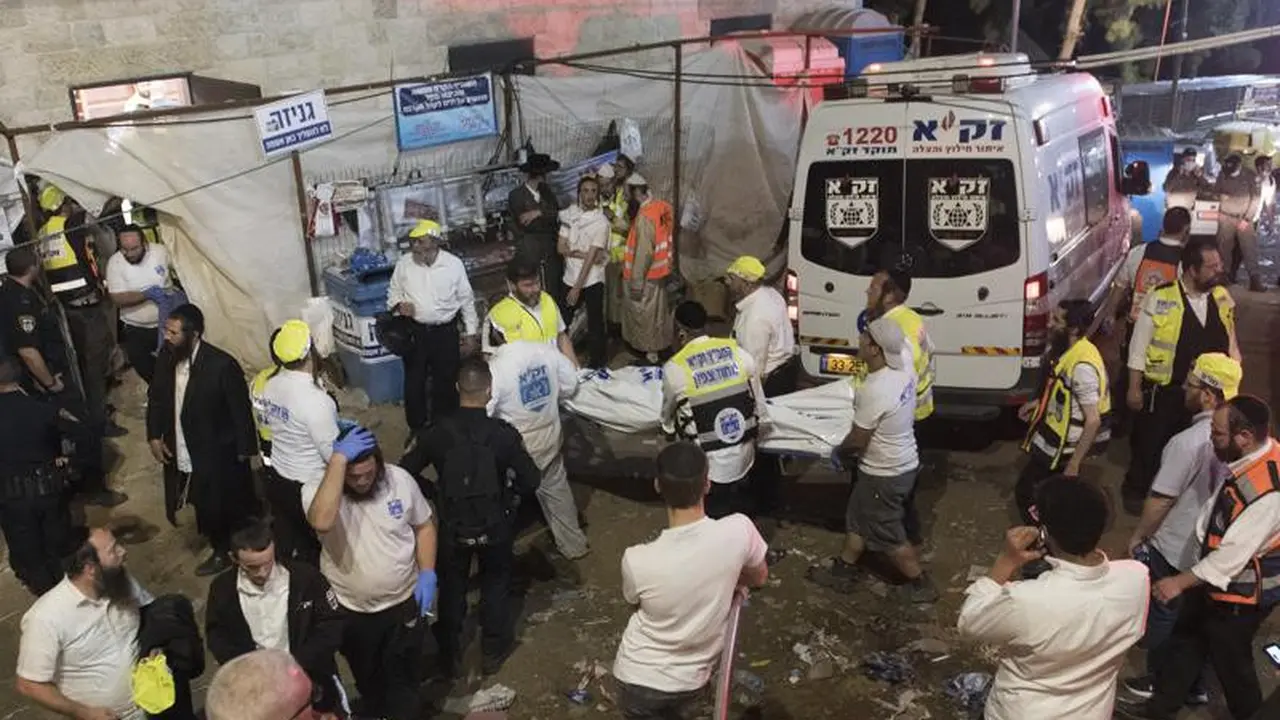Pejabat keamanan dan penyelamat Israel membawa tubuh korban yang meninggal selama perayaan Lag Ba'Omer di Mt. Meron di Israel utara, Jumat, 30 April 2021. (Foto: AP)