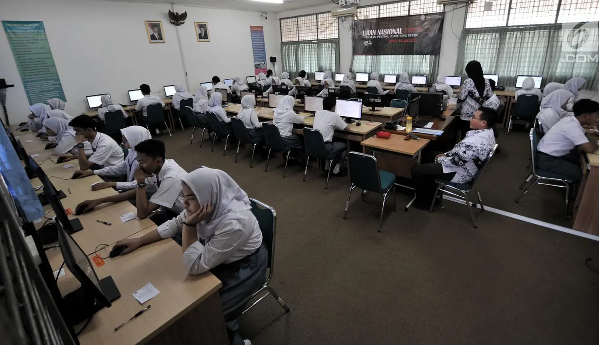 Guru mengawasi yang mengikuti Ujian Nasional Berbasis Komputer (UNBK) di Sekolah Menengah Kejuruan Negeri  (SMKN) 50 Jakarta, Senin (25/3). Sebanyak 69.407 siswa dari 578 SMK di DKI Jakarta mengikuti UNBK yang diselenggarakan pada 25-28 Maret 2019. (merdeka.com/Iqbal S. Nugroho)