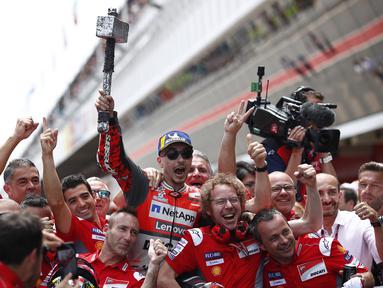 Pebalap Ducati, Jorge Lorenzo, melakukan selebrasi usai menjuarai MotoGP 2018 di Sirkuit Catalunya, Spanyol, Minggu (17/6/2018). Lorenzo menjadi yang tercepat dengan catatan waktu 40 menit 13,566 detik. (AP/Eric Alonso)
