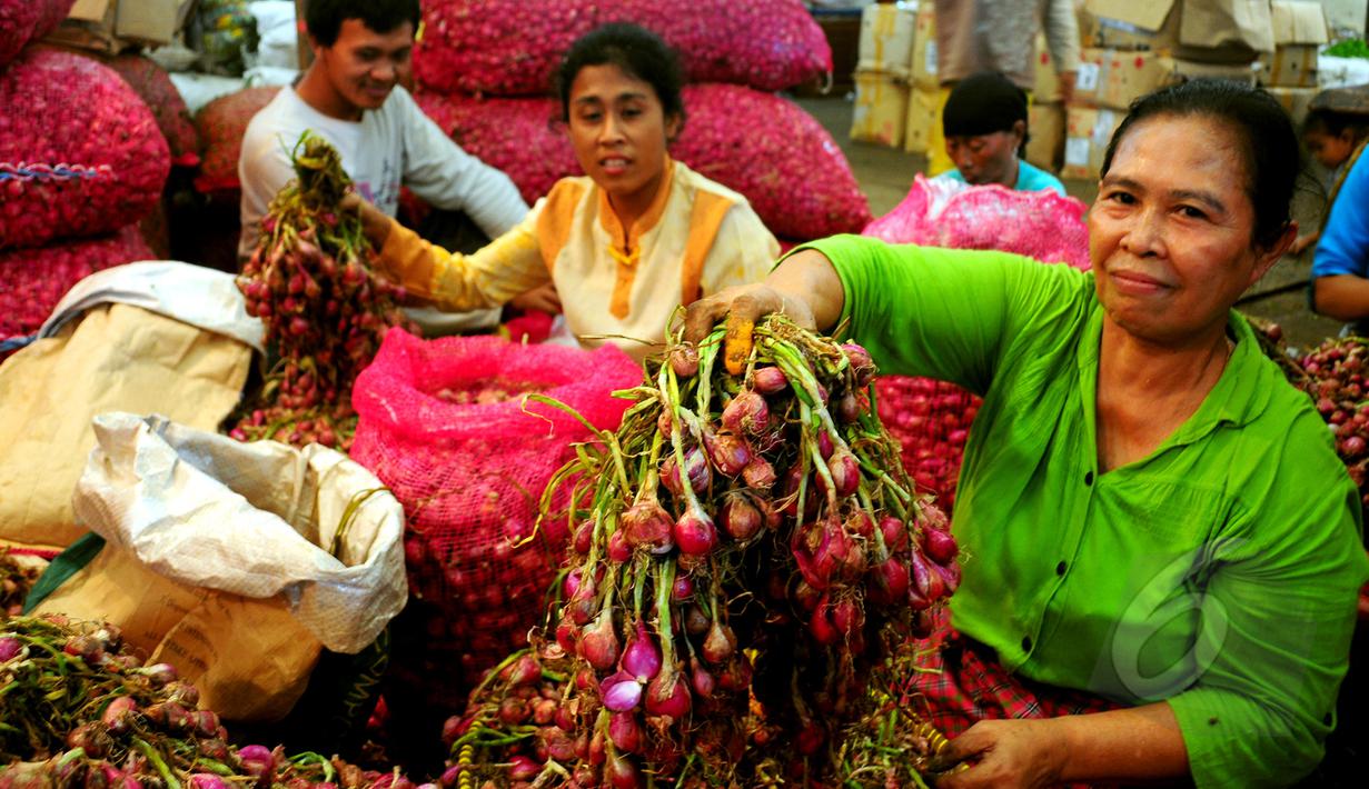 Seorang pedagang menunjukkan bawang merah di Pasar Induk sayur dan buah, Kramat Jati, Jakarta, Jumat, (13/3/2015). Harga bawang merah di sejumlah pasar menembus Rp 30 ribu per kg atau mengalami kenaikan sekitar Rp 2000-5000/kg. (Liputan6.com/Yoppy Renato)