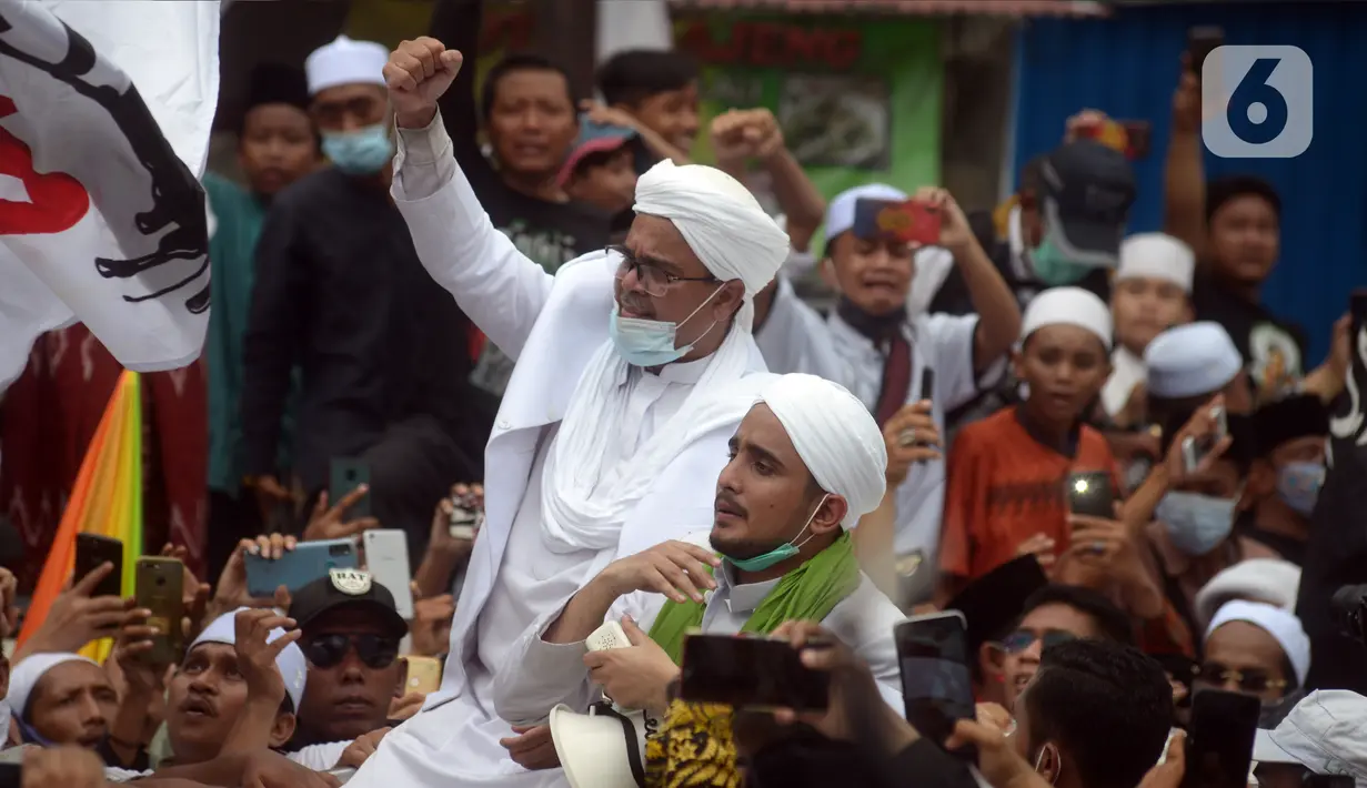 Rizieq Shihab menyapa massa pendukungnya saat tiba di kediamannya di Jalan Petamburan, Jakarta, Selasa (10/11/2020). Rizieq Shihab tiba di kediamannya usai pulang dari Arab Saudi. (merdeka.com/Imam Buhori)