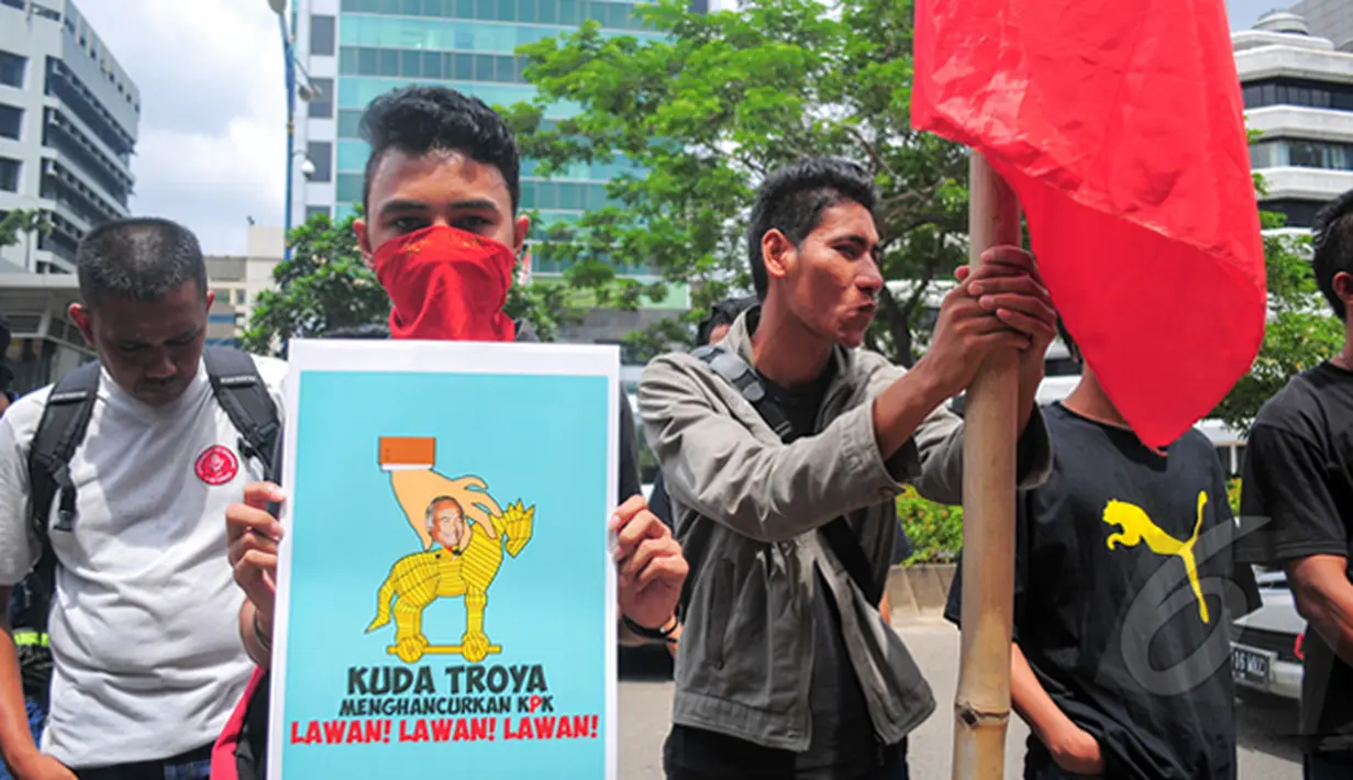 Seorang demonstran membawa poster kuda troya di depan Gedung KPK, Jakarta, Rabu (4/3/2015). Aksi tersebut mengecam keputusan Plt Ketua KPK Taufiequrachman Ruki yang melimpahkan kasus Komjen Pol Budi Gunawan ke Kejaksaan Agung. (Liputan6.com/Yoppy Renato)