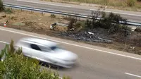 Lempengen besi panjang yang menjadi pembatas antara jalan raya dan batas rumput terlihat rusak. (Cesar Manso/AFP)