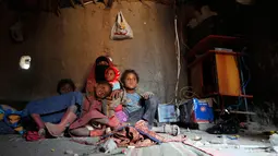 Seorang wanita Yaman bersama anak-anaknya berada di tenda tempat tinggal mereka di kamp pengungsian di Sanaa, Yaman, (15/4). Jutaan warga melarikan diri hingga ke wilayah dataran tinggi seperti Taez. (AFP Photo / Mohammed Huwais)
