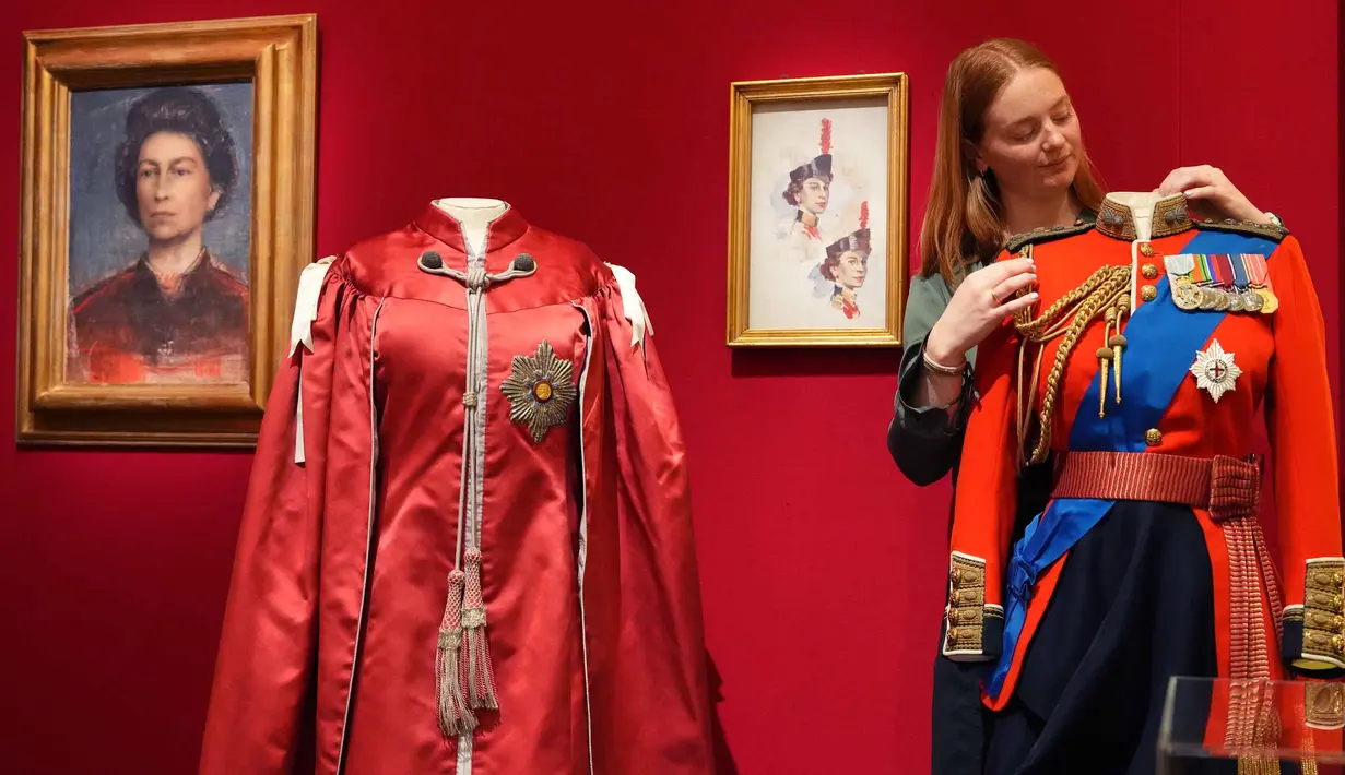 Pameran ini menyoroti gaya khas Inggris Ratu Elizabeth II berikut perannya dalam diplomasi melalui fashion selama 70 tahun masa jabatannya. Tampak dalam foto, seorang anggota staf Royal Collection Trust menyesuaikan tunik seragam Kolonel Kepala Grenadier Guards yang dikenakan oleh Ratu Elizabeth II, yang dipamerkan di pameran 'Queen Elizabeth II: Her Life in Style', di The King's Gallery, Istana Buckingham, London, Inggris, Kamis 9 April 2026. (AP Photo/Kirsty Wigglesworth)