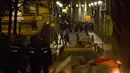 Petugas polisi saat terlibat bentrok dengan imigran di Madrid, Spanyol, Kamis (15/3). Bentrokan berawal dari aksi protes imigran atas meninggalnya seorang pedagang jalanan asal Senegal. (AFP Photo/Olmo Calvo)