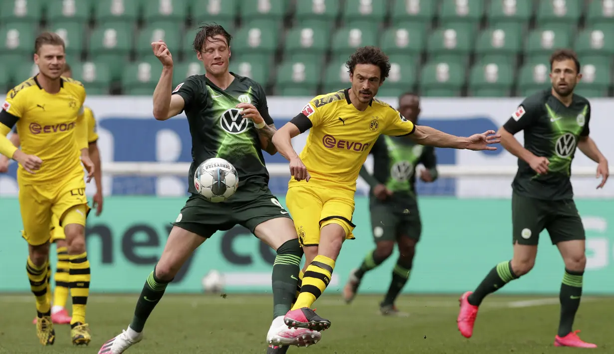 Pemain Borussia Dortmund, Thomas Delaney, melepaskan tendangan saat pertandingan melawan Wolfsburg pada laga Bundesliga, Minggu (24/5/2020). Borussia Dortmund menang 2-0 atas Wolfsburg. (AP/Michael Sohn)