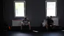 Petinju amatir beristirahat setelah sesi latihan di All Stars Boxing Club, Kiev, Ukraina, 10 Mei 2022. Suara hip hop bercampur dengan bunyi pukulan tinju saat sekelompok petinju melepaskan stres terpendam di tengah perang Ukraina. (Sergei SUPINSKY/AFP)