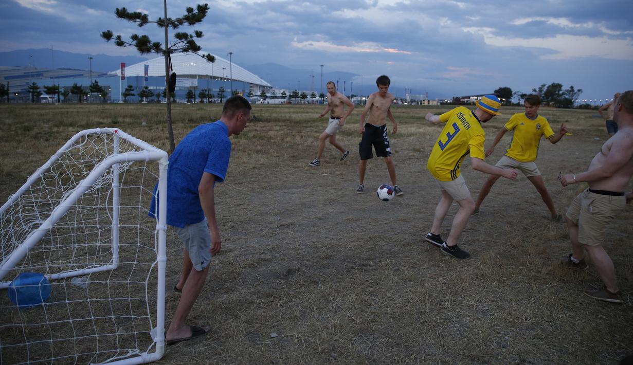 Sejumlah suporter Swedia bergembira bermain bola di sekitar Pantai Sochi, Jumat (22/6/2018). Para suporter bersiap untuk menyaksikan laga Piala Dunia 2018 antara Swedia melawan Jerman. (AP/Rebecca Blackwell)