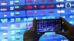 Karyawan mengambil gambar layar Indeks Harga Saham Gabungan (IHSG) di Bursa Efek Indonesia, Jakarta, Jumat (22/1/2021). Sebanyak 111 saham menguat, 372 tertekan, dan 124 lainnya flat. (Liputan6.com/Johan Tallo)