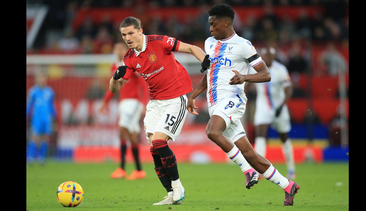 Pemain Manchester United, Marcel Sabitzer (kiri) berebut bola dengan pemain Crystal Palace, Albert Sambi Lokonga pada laga pekan ke-22 Liga Inggris 2022/2023 di Old Trafford, Manchester, Sabtu (04/02/2023). Sabitzer bermain dengan 9 rekan lainnya setelah Casemiro mendapatkan kartu merah dari wasit setelah terbukti mencekik pemain Crystal Palace.  (AFP/Lindsey Parnaby)