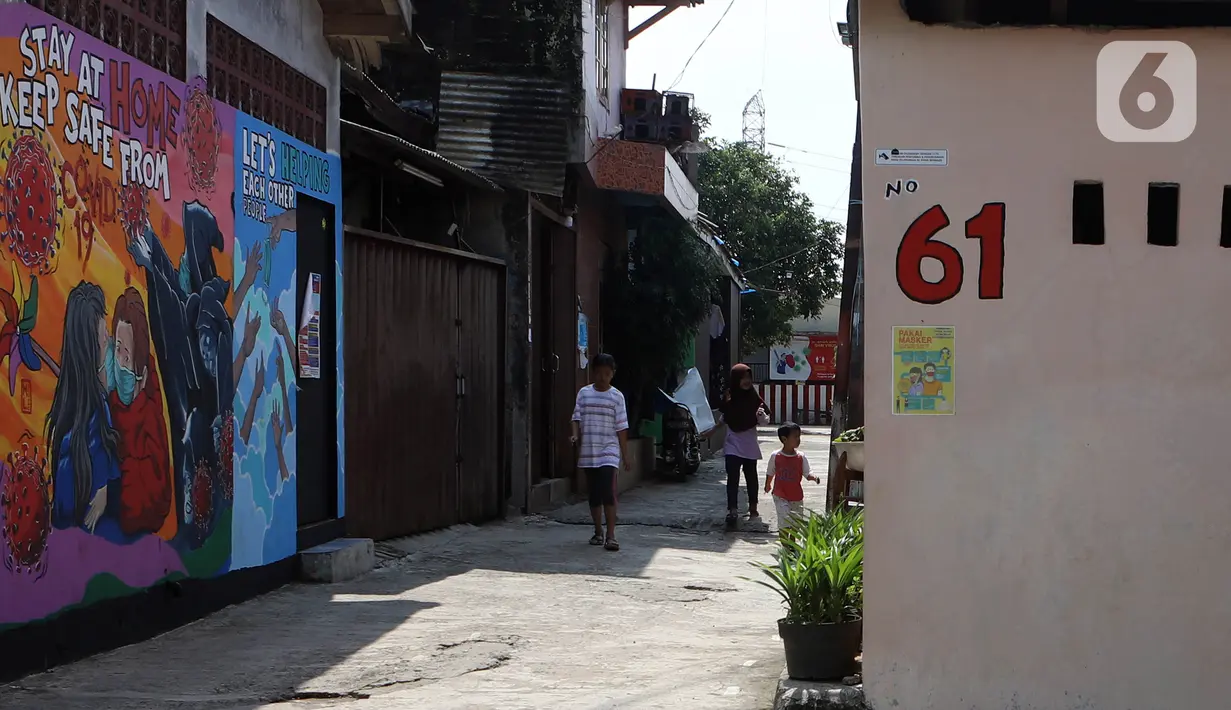 Anak-anak berjalan di depan mural bertema virus corona COVID-19 yang menghiasi dinding rumah di kawasan Pangkalan Jati Baru, Depok, Jawa Barat, Selasa (2/6/2020). Mural bertulis ‘Stay At Home, Keep Safe From COVID-19’ itu untuk mengingatkan warga akan bahaya COVID-19. (Liputan6.com/Johan Tallo)