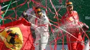 Lewis Hamilton (kiri) dan Sebastian Vettel (kanan) kemenangannya di atas podium usai balapan F1 GP Italia, di arena Monza, Italia (3/9). Dengan kemenangan di Sirkuit Monza, Hamilton kini mengoleksi 238 poin. (AP Photo/Antonio Calanni)