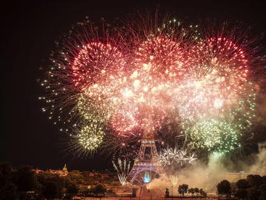 Kembang api menerangi Menara Eiffel selama perayaan Hari Bastille di Paris, Kamis (14/7/2022) malam. Perayaan yang digelar setiap tanggal 14 Juli ini dalam rangka untuk memperingati penyerbuan benteng penjara Bastille pada 14 Juli 1789 silam. (AP Photo/Lewis Joly)