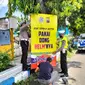 Petugas lantas Polres Situbondo mamasang papan imbauan mudik aman di jalur pantura Situbondo (Hermawan Arifianto/Liputan6.com)