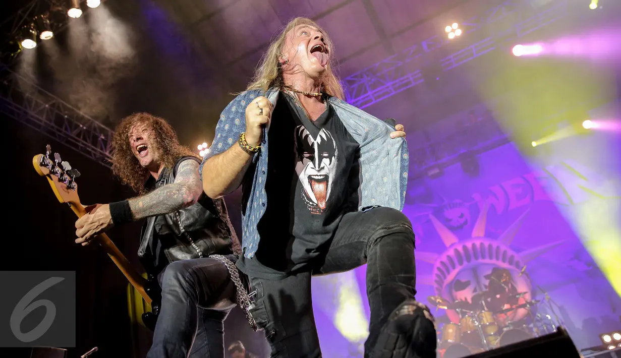 Vokalis Helloween, Andi Deris (kanan) menjulurkan lidah saat aksi panggung di Senayan, Jakarta, Kamis (22/10/2015). Penampilan Helloween di Jakarta merupakan bagian dari tur Helloween My God-Given Right Tour 2015. (Liputan6.com/Faizal Fanani)