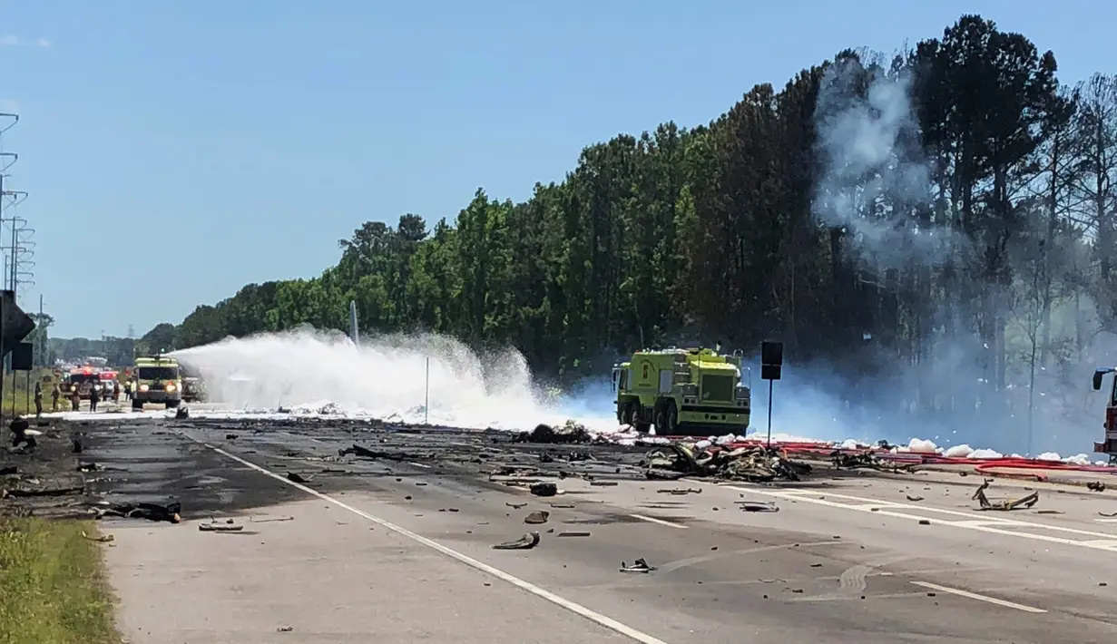 Personel darurat di lokasi jatuhnya pesawat kargo militer Amerika Serikat di jalan raya dekat bandara Savannah, Georgia, Rabu (2/5). Pesawat C-130 Hercules dari Garda Nasional Puerto Rico itu jatuh setelah lepas landas dari Savannah (James Lavine via AP)