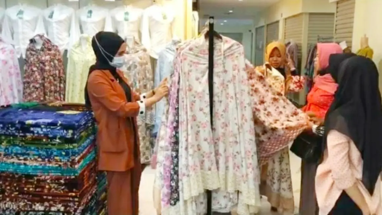 Emak-emak memilih mukenah raga motif yang dijual di pasar Pekanbaru.