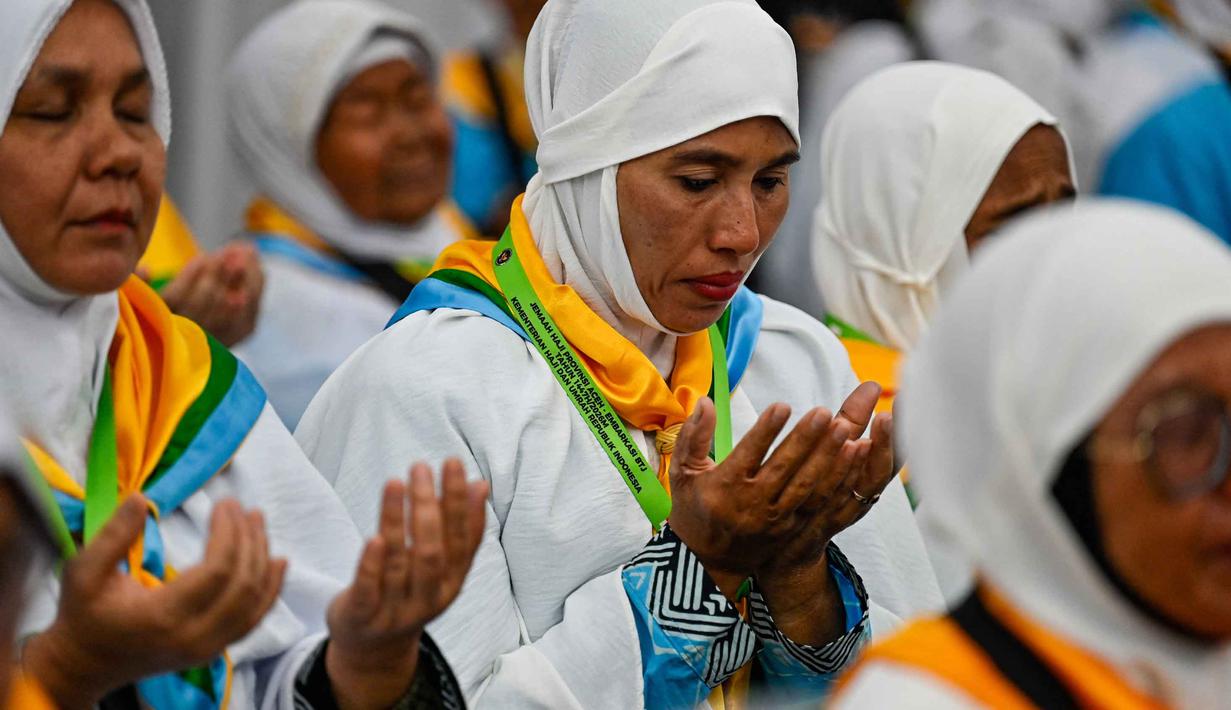 Para calon jemaah haji Indonesia berdoa selama sesi pelatihan keselamatan pra-keberangkatan di pusat embarkasi haji Banda Aceh pada Kamis 14 Mei 2026. (CHAIDEER MAHYUDDIN/AFP)