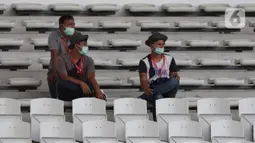 Pewarta mengenakan masker saat meliput laga kualifikasi Grup H Piala AFC 2020 antara PSM Makassar melawan Kaya FC-Iloilo, Jakarta, Selasa (10/3/2020). Pertandingan dilaksanakan tanpa dihadiri penonton sebagai antisipasi penyebaran virus Corona COVID 19. (Liputan6.com/Helmi Fithriansyah)