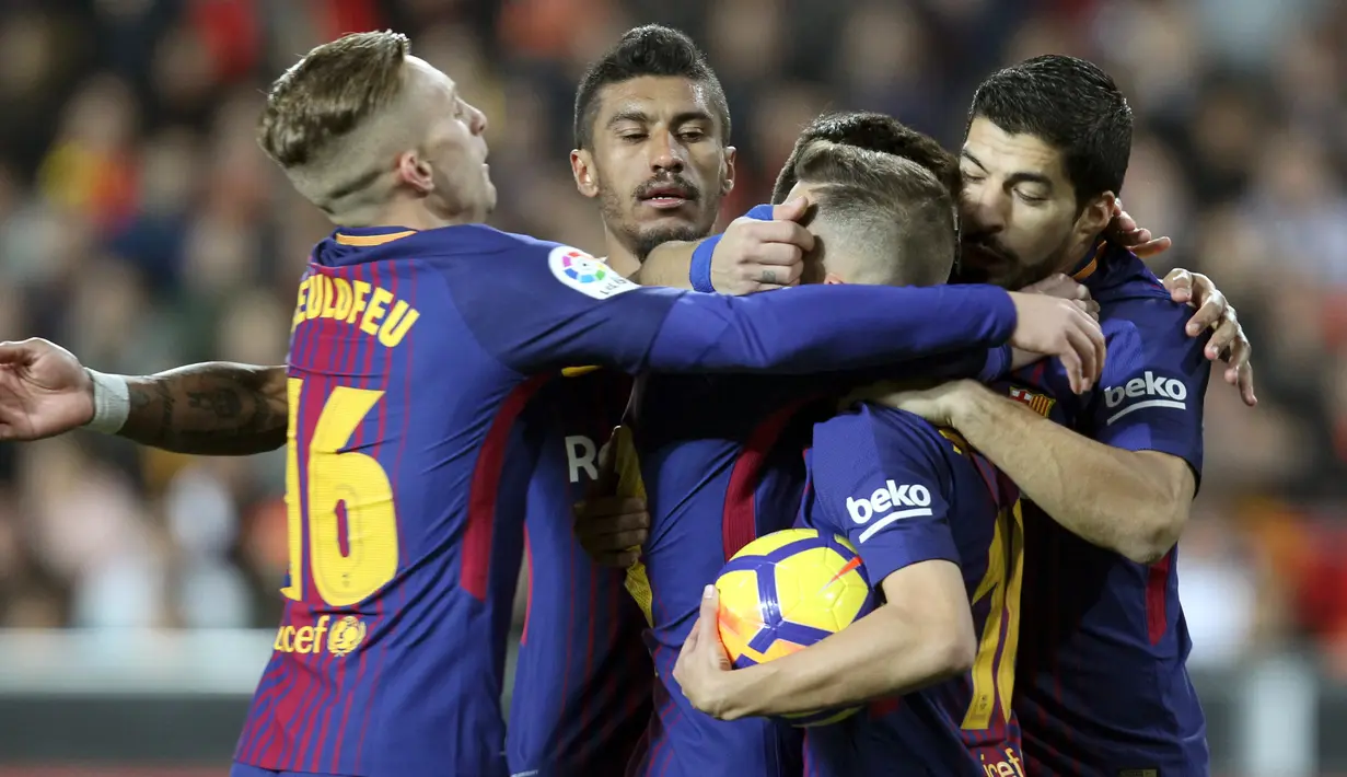 Pemain Barcelona, Jordi Alba, mendapat ucapan selamat dari rekan setimnya, Suarez setelah mencetak gol ke gawang Valencia pada lanjutan La Liga Primera Division di Stadion Mestalla, Minggu (26/11). Barcelona ditahan imbang Valencia 1-1.  (AP/Alberto Saiz)