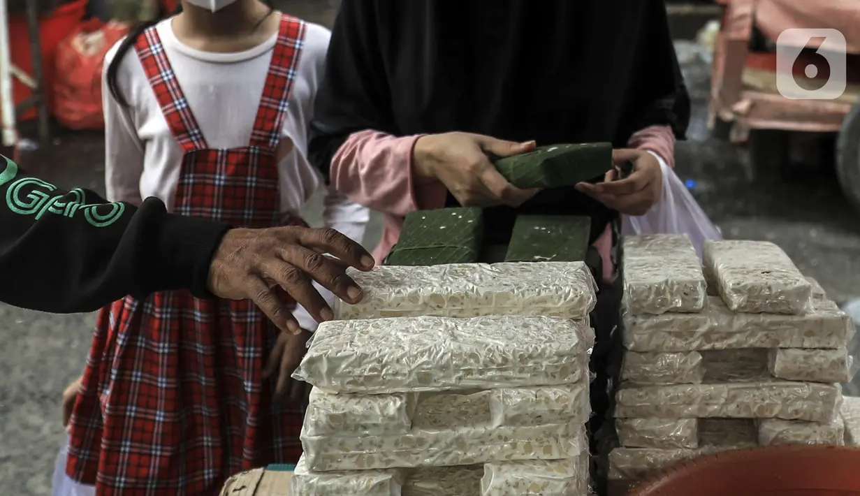 Warga membeli tempe di Pasar Kebayoran Lama, Jakarta, Selasa (15/2/2022). Ketua Umum Gabungan Koperasi Produsen Tempe Tahu (Gakoptindo) Aip Syarifuddin menyatakan akan mogok produksi tempe tahu yang akan dilakukan mulai 21-23 Februari 2022. (Liputan6.com/Johan Tallo)