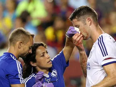 Pemain Chelsea Gary Cahill mendapatkan pengobatan dari tim medis akibat terluka karena duel udara saat mencetak gol pada Laga International Champions Cup di FedEx Field, AS, Rabu (29/7/2015) pagi WIB. (AFP Photo/Nicholas Kamm)