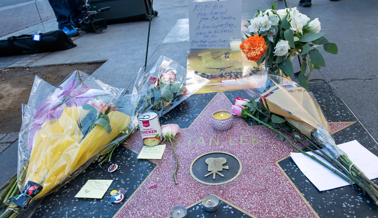 Penggemar meletakkan karangan bunga dan memorabilia lainnya di atas bintang Walk of Fame milik pencipta sekaligus legenda komik-komik Marvel, Stan Lee di Hollywood, California, Senin (12/11). Stan Lee meninggal dunia pada usia 95. (VALERIE MACON / AFP)