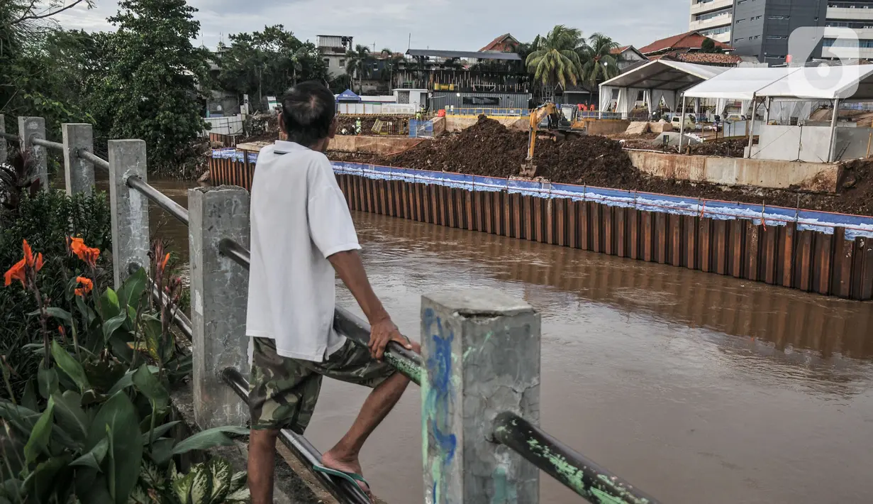 Warga melihat proyek pembangunan Sodetan Kali Ciliwung di Bidara Cina, Kecamatan Jatinegara, Jakarta Timur, Rabu (26/10/2022).  Proyek pembangunan Sodetan Kali Ciliwung-Kanal Banjir Timur (KBT) yang merupakan bagian dari program normalisasi sungai guna mengantisipasi banjir di Ibu Kota tersebut hingga kini terus dikerjakan. (merdeka.com/Iqbal S. Nugroho)