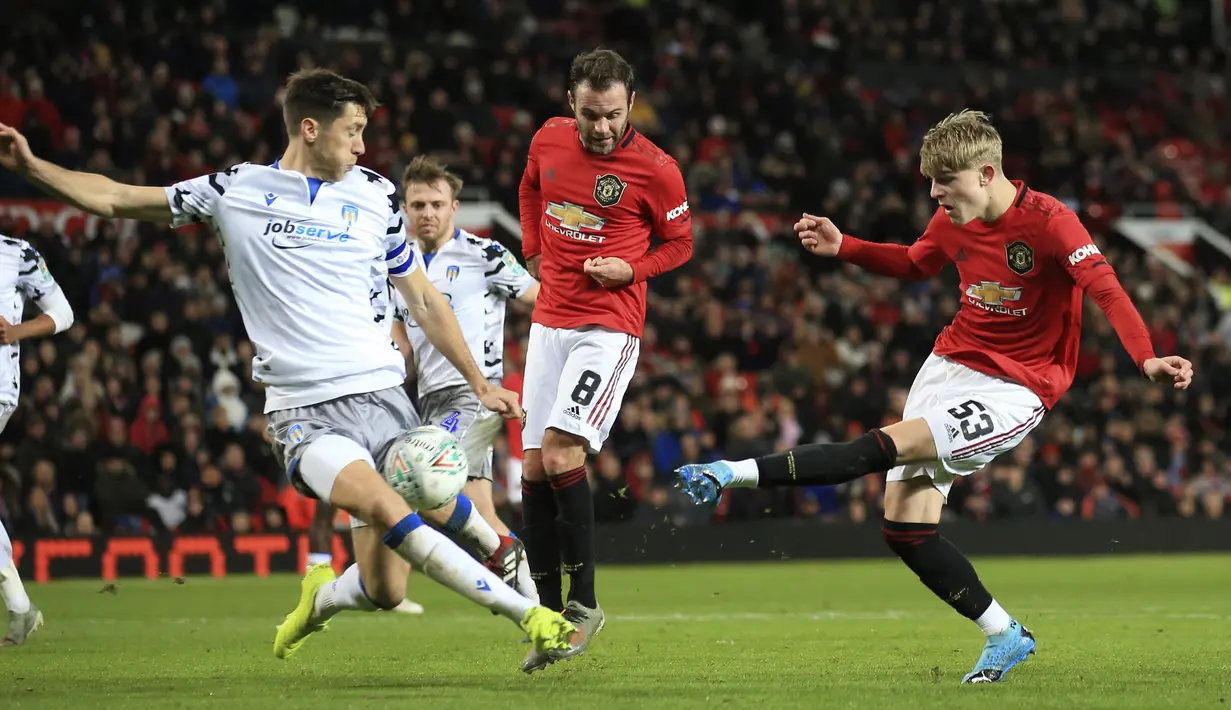 Bek Colchester United, Luke Prosser berusaha menahan bola tembakan bek Manchester United, Brandon William pada perempat final Piala Liga Inggris di Old Trafford (18/12/2019). MU menang telak 3-0 atas Colchester United dan melaju ke semifinal. (AP Photo/Jon Super)