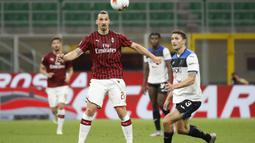 Pemain AC Milan Zlatan Ibrahimovic berebut bola dengan pemain Atalanta Mattia Caldara pada pertandingan Serie A di Stadion San Siro, Milan, Italia, Jumat (24/7/2020). Pertandingan berakhir 1-1. (AP Photo/Antonio Calanni)