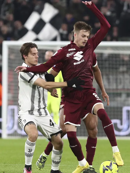 Gelandang Torino, Ivan Ilic berebut bola dengan gelandang Juventus Nicolo Fagioli pada pekan ke-24 Liga Italia di Stadion Allianz, Rabu (1/3/2023) dini hari WIB. Hasil tersebut memperpanjang laju tak terkalahkan Juventus dalam enam laga terakhir, tiga di antaranya kemenangan beruntun. (Fabio Ferrari/LaPresse via AP)