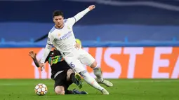 Pemain Inter Milan Alessandro Bastoni (kiri) menjegal pemain Real Madrid Luka Jovic pada pertandingan sepak bola Grup D Liga Champions di Stadion Santiago Bernabeu, Madrid, Spanyol, 7 Desember 2021. Real Madrid menang 2-0. (OSCAR DEL POZO/AFP)