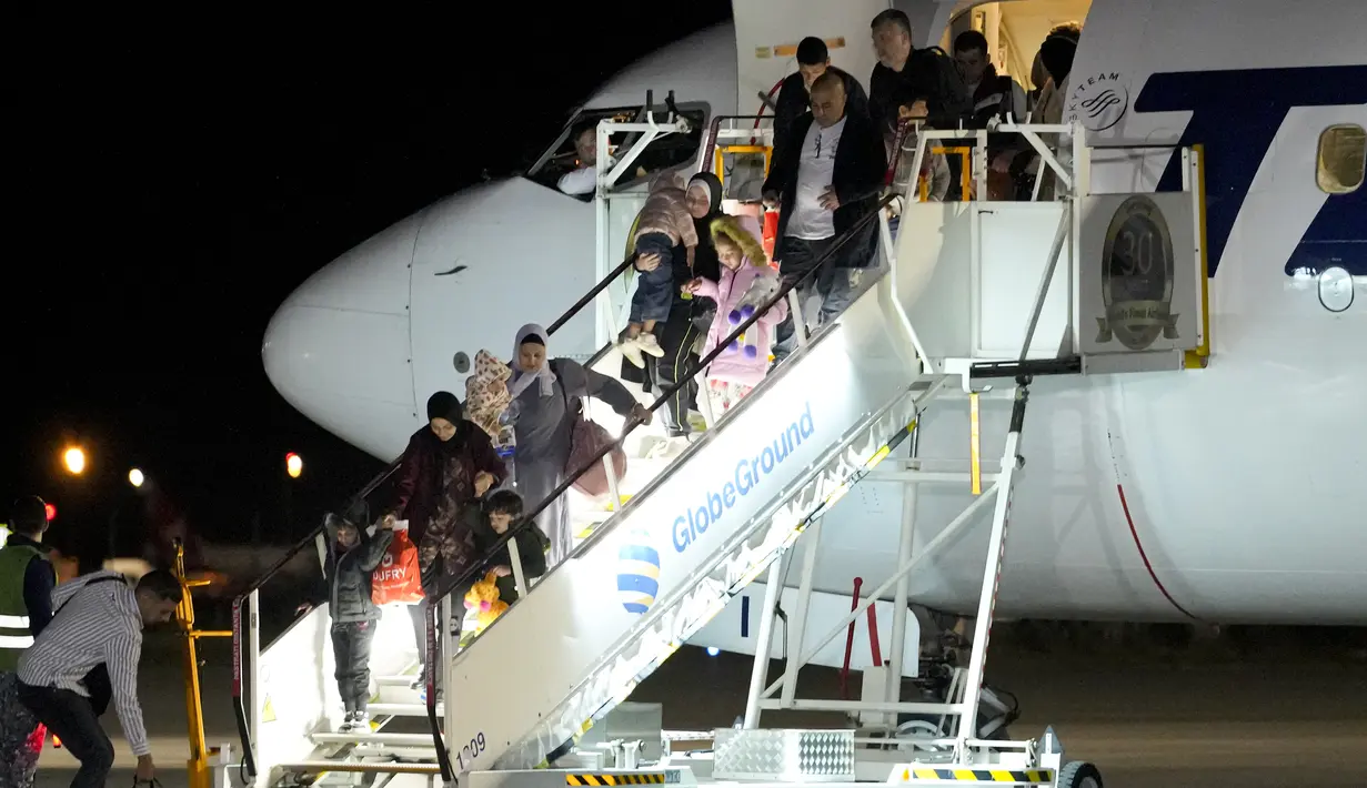 Rombongan 93 warga negara Rumania mendarat di pangkalan udara dekat ibu kota Rumania dalam penerbangan dari Mesir setelah dievakuasi dari Jalur Gaza. (AP Photo/Andreea Alexandru)