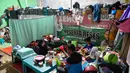 Warga pun terpaksa terus menetap dan beraktivitas di tenda-tenda penampungan dengan fasilitas seadanya yang dinilai kurang layak untuk ditinggali dalam jangka waktu lama. Tampak dalam foto, sebuah keluarga berbuka puasa Ramadan di tempat penampungan sementara bagi korban banjir di Meurah Dua, Kabupaten Pidie Jaya, Provinsi Aceh, pada 21 Februari 2026, setelah banjir dan tanah longsor dahsyat melanda Sumatra, akhir November 2025 lalu. (CHAIDEER MAHYUDDIN/AFP)