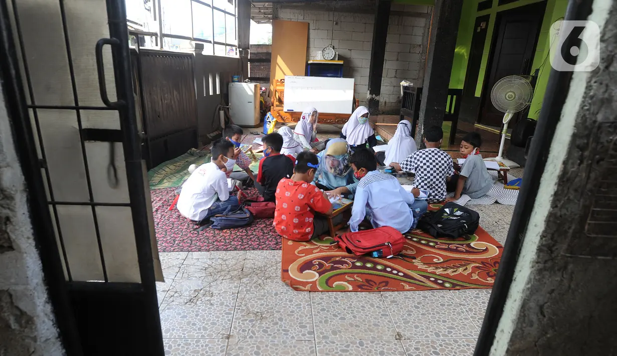Murid kelas IV SD Muhammadiyah 37 belajar di teras rumah seorang guru di kawasan Pondok Cabe Udik, Tangerang Selatan, Banten, Senin (10/8/2020). Kegiatan belajar mengajar (KBM) tatap muka ini dilakukan dengan menerapkan standar protokol kesehatan. (merdeka.com/Arie Basuki)